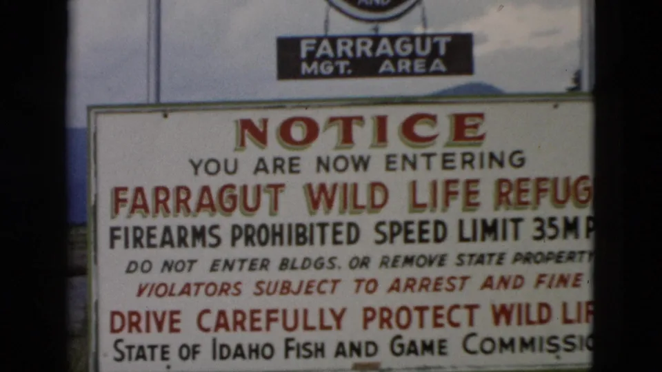 1958 8mm frame of the Farragut Wild Life Refuge entrance notice, including visitor warnings and Fish and Game Commission text.