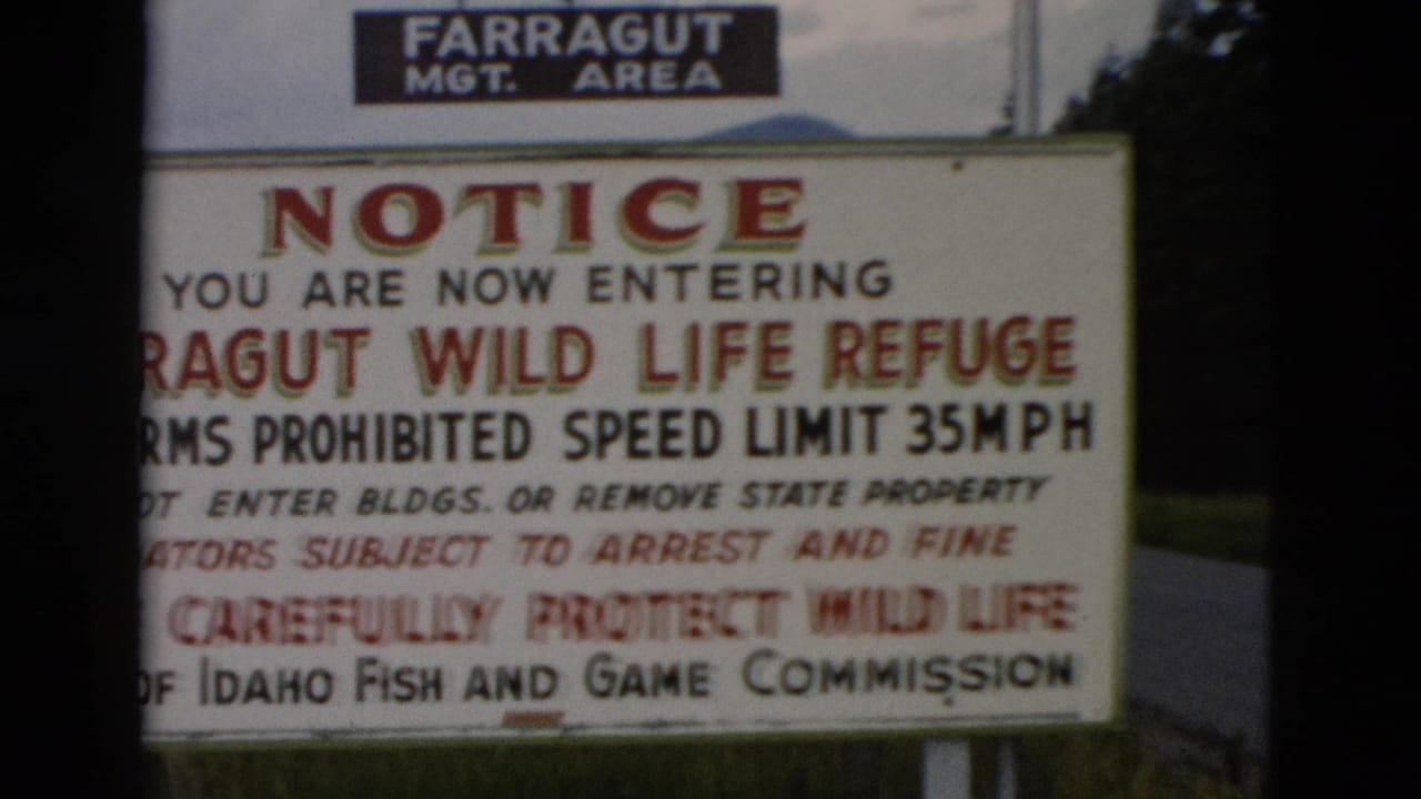 Partly obscured close view of the Farragut refuge notice sign beside a dark film edge.