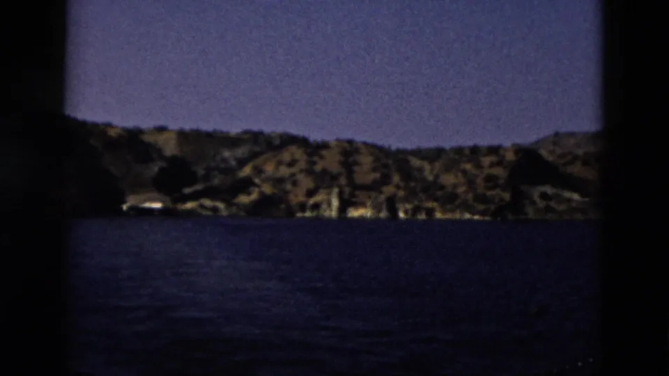 1958 Yellowstone home-movie view of rippled lake water and a distant hilly shore.