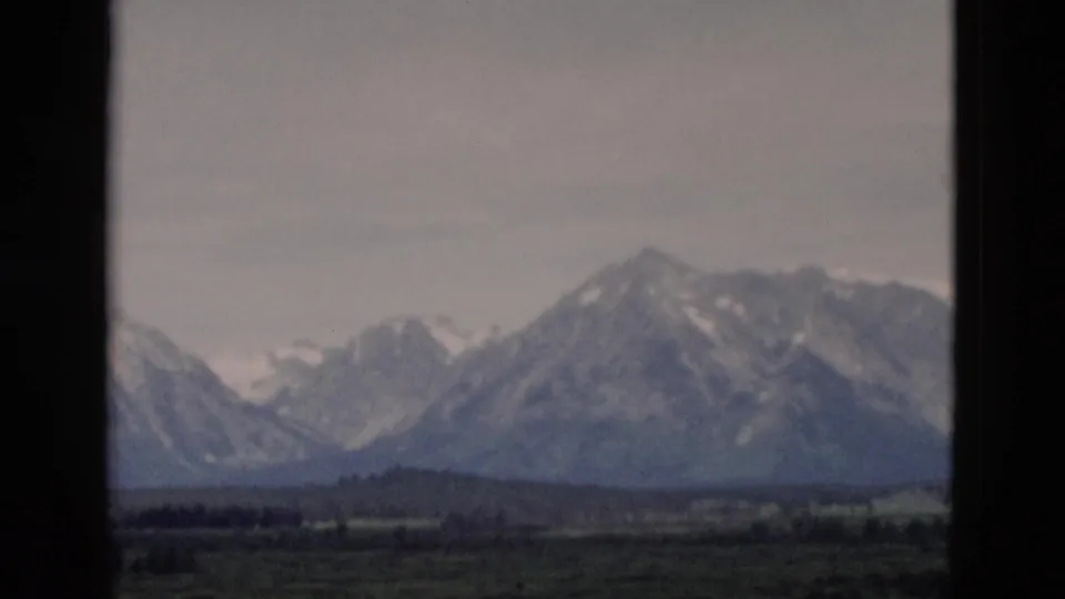 The final frame holds on a hazy mountain range and low foreground hills, consistent with the 1958 Yellowstone, Wyoming metadata.