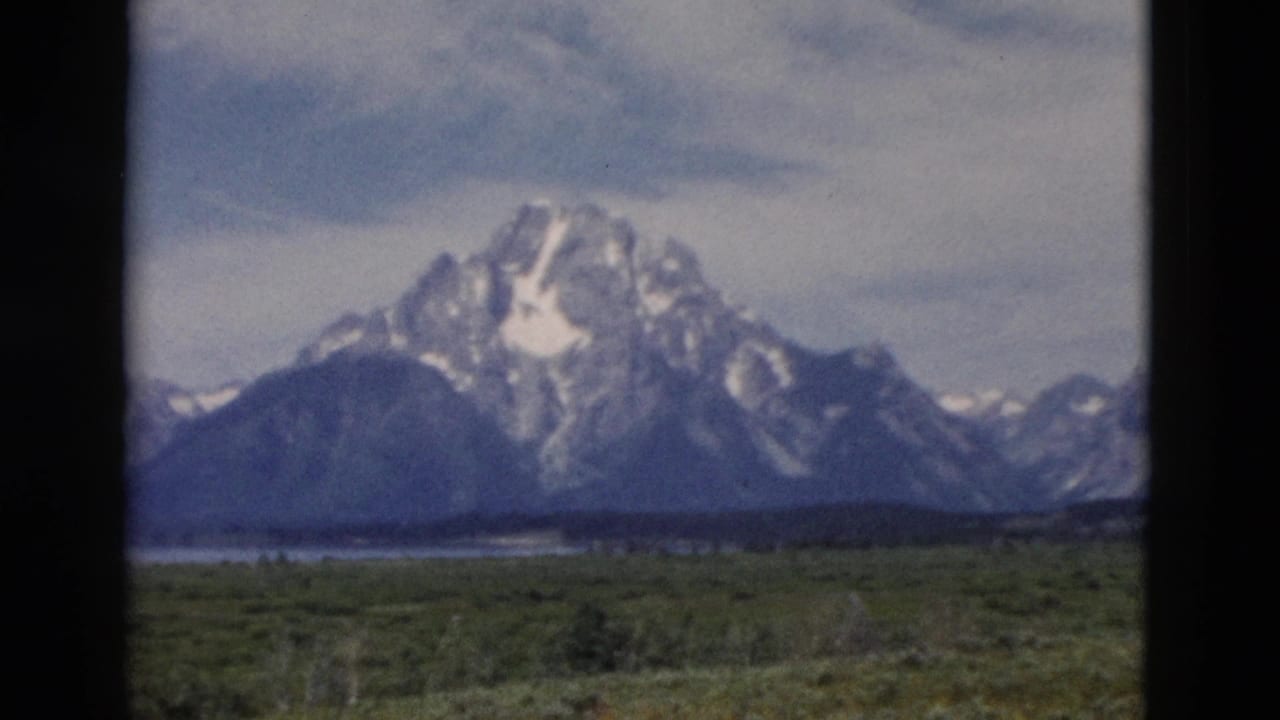 Color 8mm frame showing the Wyoming mountain range and valley, with dark projector or gate edges visible.