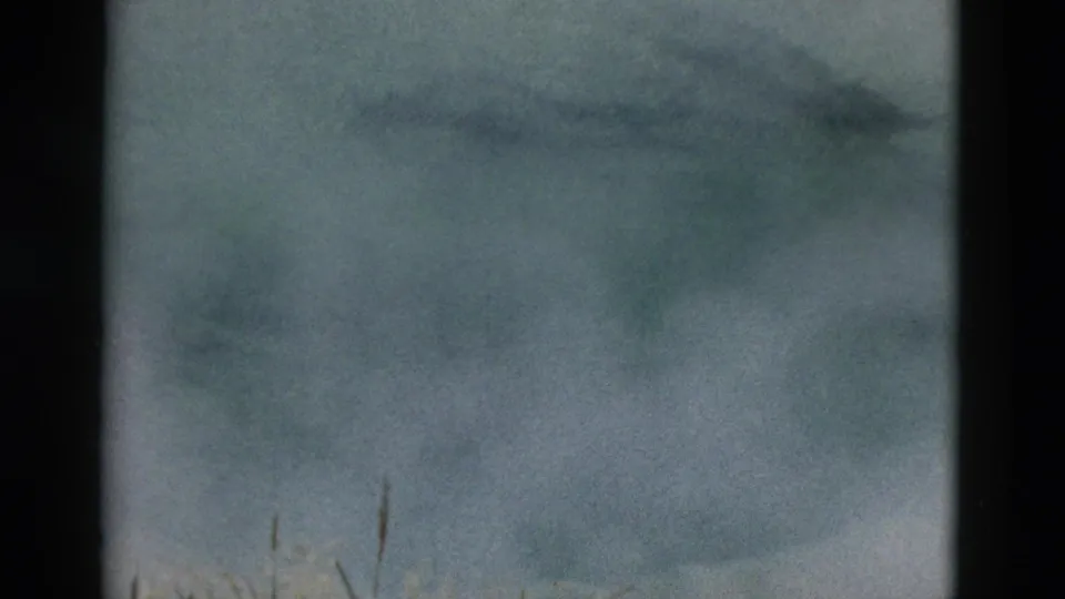 Yellowstone geothermal pond with light steam over ice and snow-toned water, recorded in soft 1950s 8mm color.