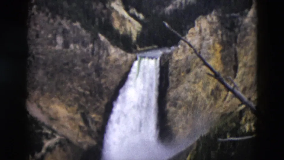 End frame of the 1958 Yellowstone 8mm clip, with the waterfall descending below canyon rock and trees.
