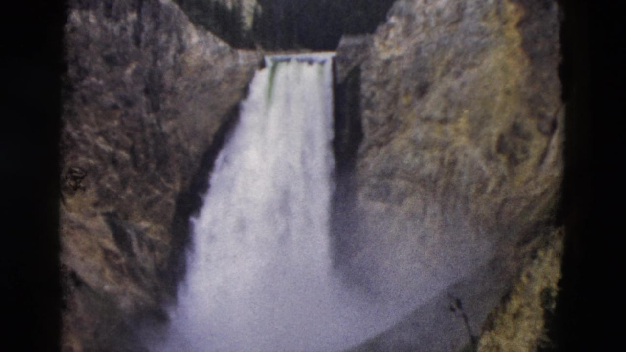 Yellowstone waterfall seen in 1958 8mm footage, with pale water dropping between rugged canyon walls.