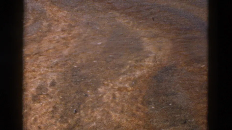 1958 Yellowstone-area aerial view of dry brown terrain framed by dark vertical bars, with grain and muted color.