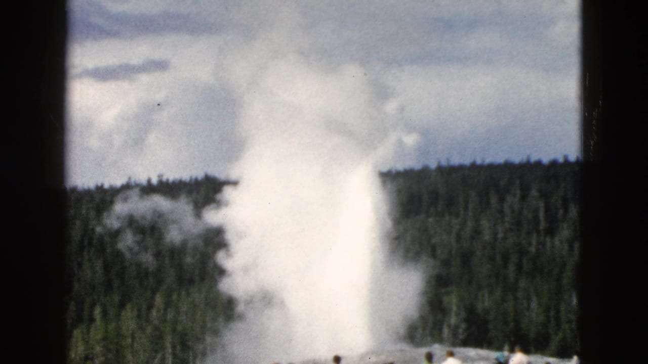 Old Faithful erupts in Yellowstone, with the white plume framed by trees, clouds, and 8mm film borders.