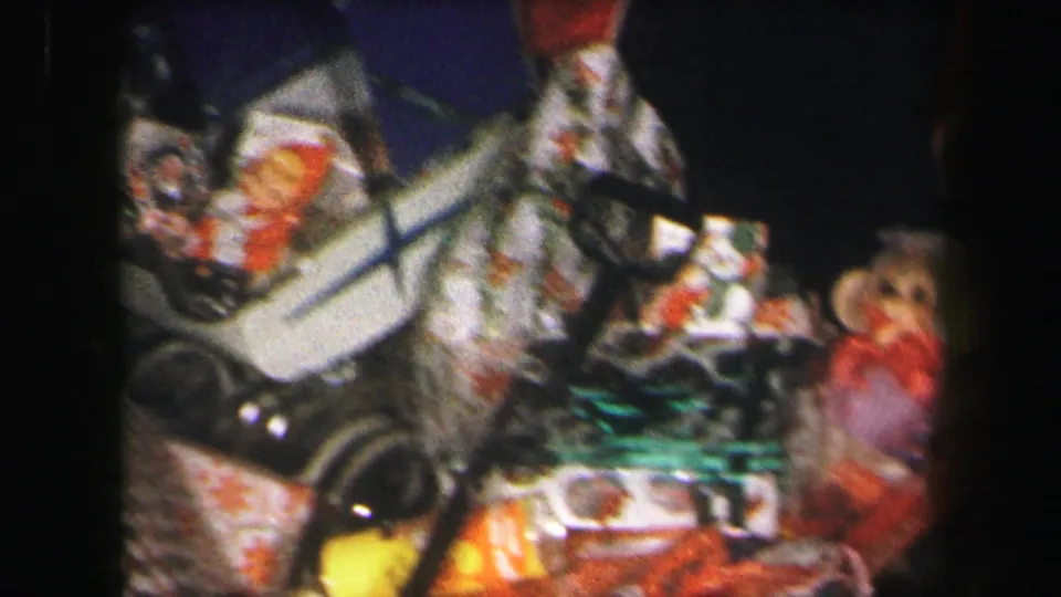 1971 8mm frame showing wrapped Christmas presents, a doll stroller, and plush toy under the tree in Lynbrook.