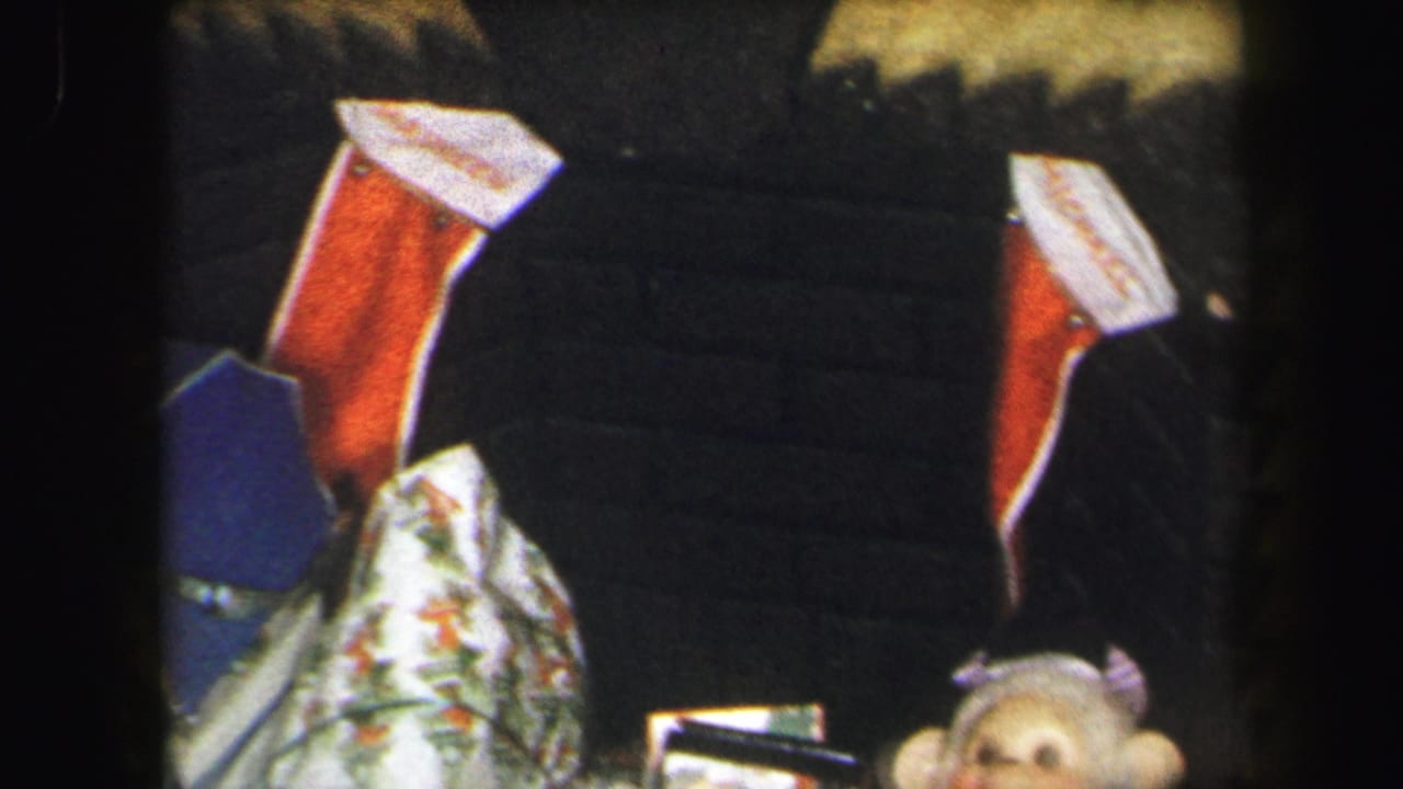 Wrapped Christmas gifts below red-and-white stockings, with part of a sock monkey near the lower edge.