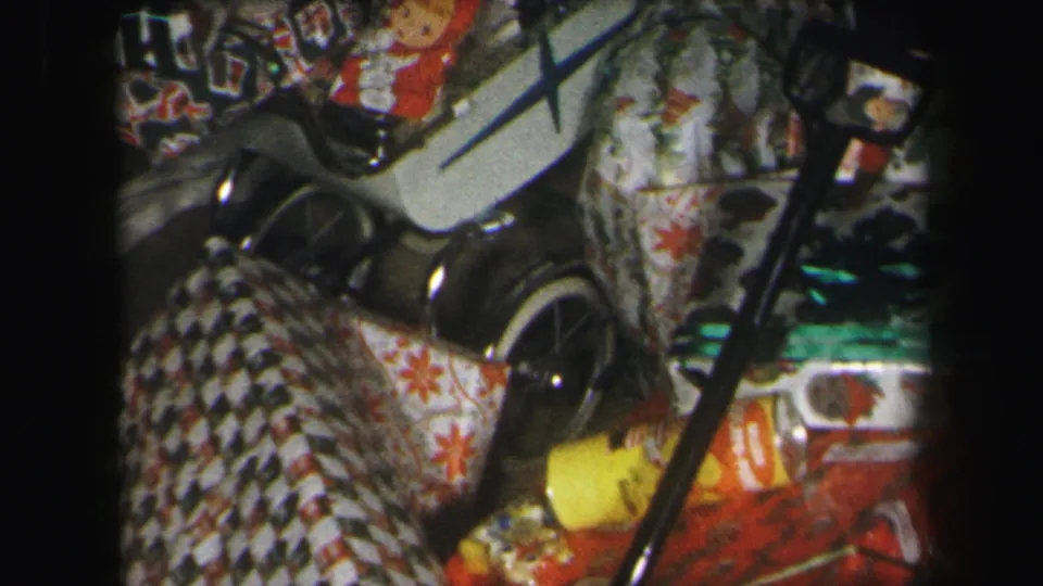 1971 Lynbrook Christmas frame focused on toy wagon wheels, wrapped presents, patterned paper, and a partial sock monkey figure.
