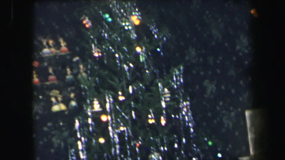1971 Lynbrook frame showing the upper Christmas tree with heavy tinsel, ornaments, and multicolor lights in soft 8mm focus.