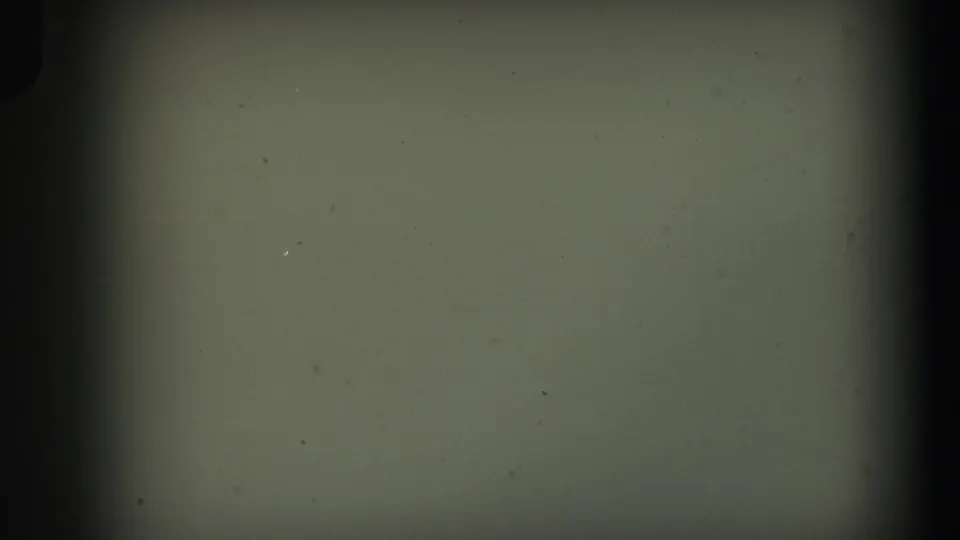 Blank or leader-like 8mm frame from the supplied 1971 Lynbrook home movie, with dust, scratches, and dark gate edges visible.