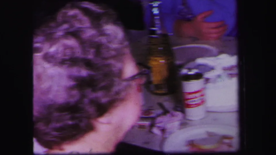 1971 Lynbrook frame showing a woman from behind near a household sink or counter with party items.