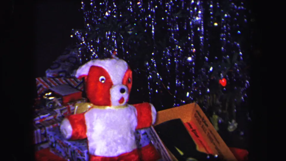 1971 Lynbrook holiday frame with a red and white plush dog beneath a decorated Christmas tree and wrapped gifts.