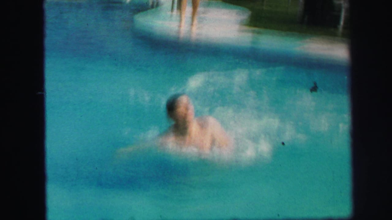 Swimmer splashes in the pool after coming off the slide.