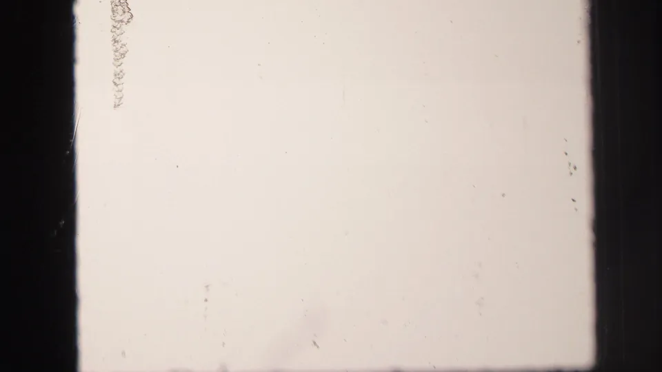 Overexposed opening frame from the 1971 Lynbrook 8mm clip, with film gate edges and faint marks visible.
