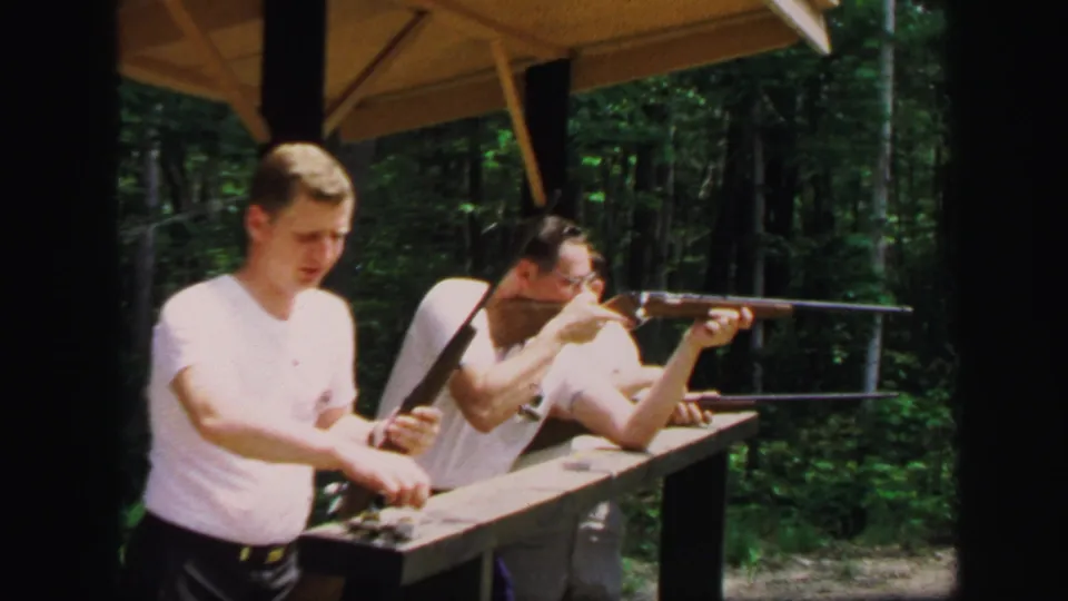 At the Lynbrook range in 1971, one young man aims a rifle from the bench as another stands close with a second rifle.
