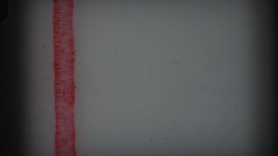 1971 Lynbrook 8mm reel-end frame showing a red vertical marker line on pale film stock with dust, grain, and dark gate edges.