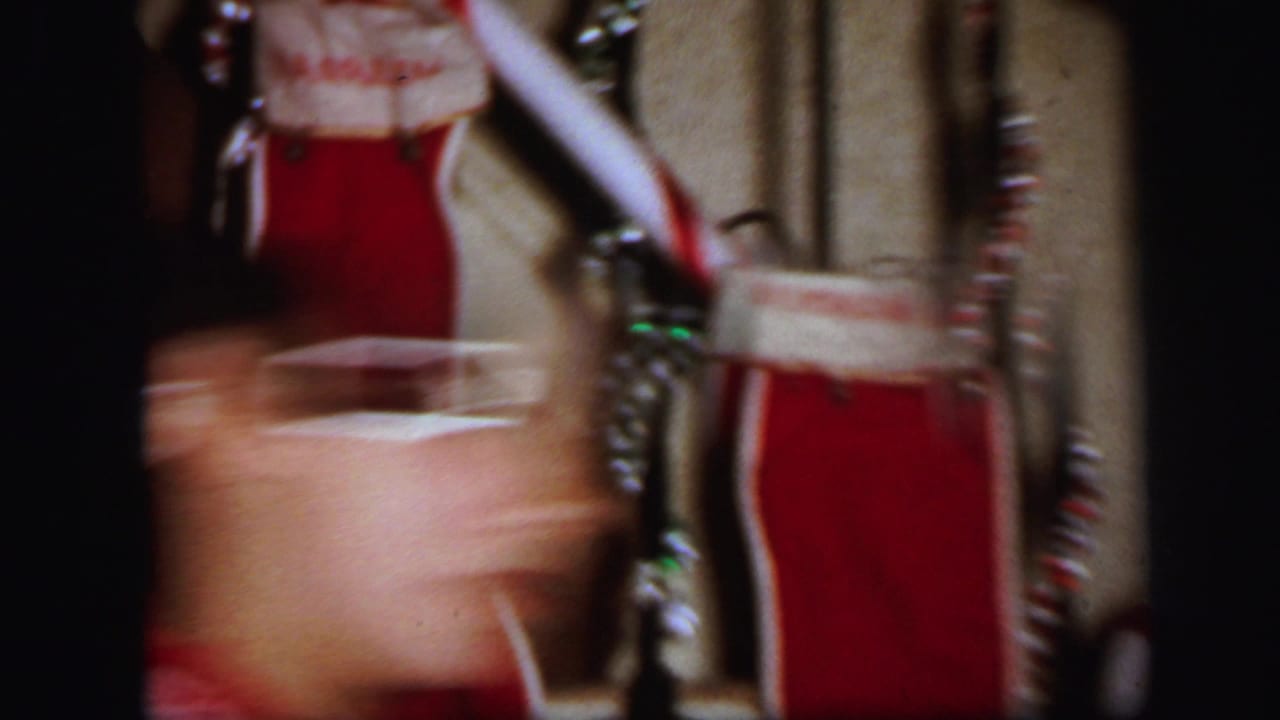 Red Christmas stockings with white trim hanging on a staircase banister.