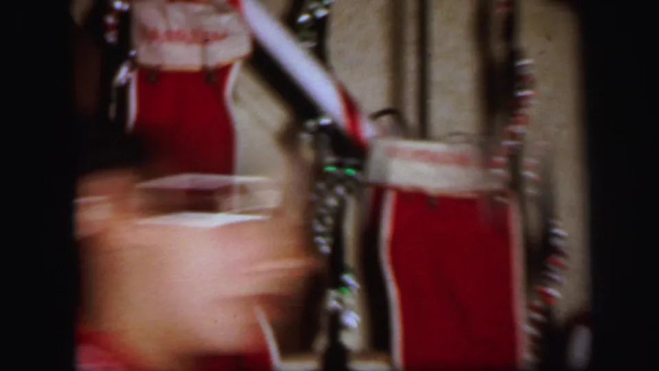 1971 Lynbrook home-movie frame showing red Christmas stockings on a wooden staircase with garland and soft indoor focus.
