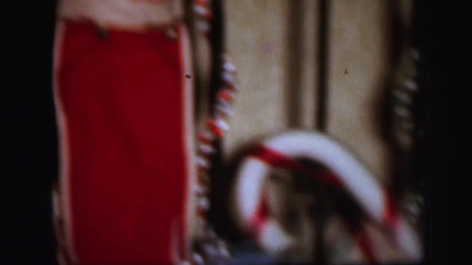 Soft 1971 8mm frame of stockings and garland on a wooden stair rail in a home Christmas display.