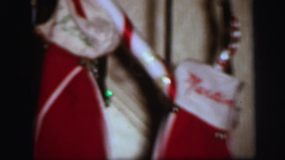 1971 Lynbrook frame showing red personalized Christmas stockings on a staircase, with one cuff partly readable.