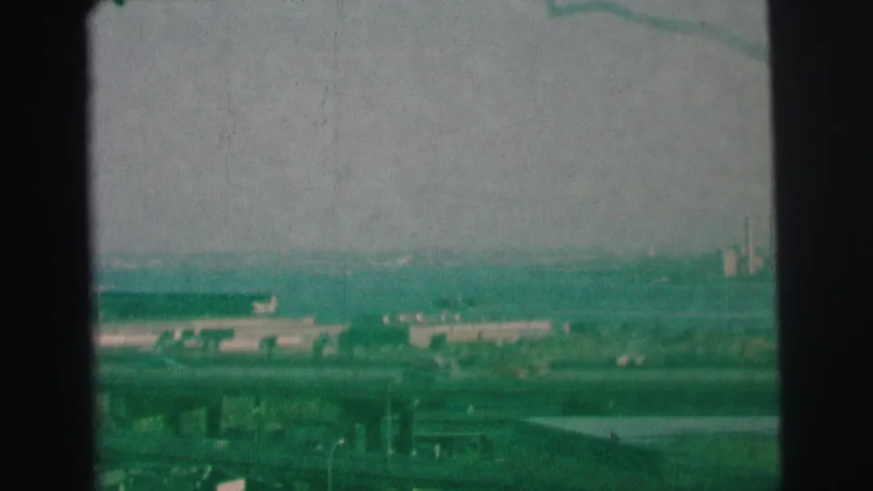 1973 Lynbrook, New York view with highways, low industrial buildings, distant smokestacks, and a hazy skyline.