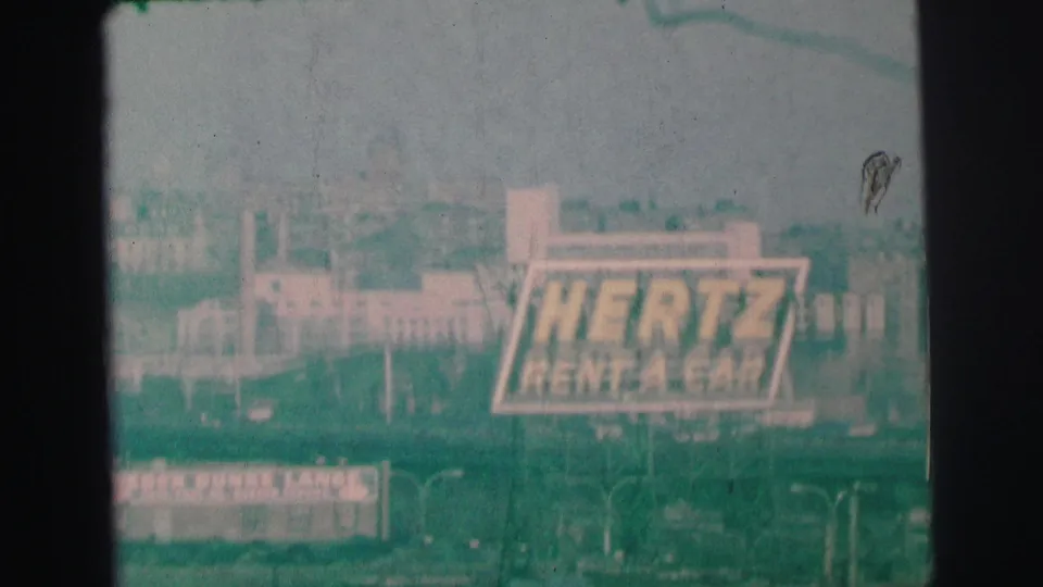 1973 Lynbrook, New York view with a Hertz Rent-A-Car sign, low buildings, and a Weber Bunke Lanes sign below.