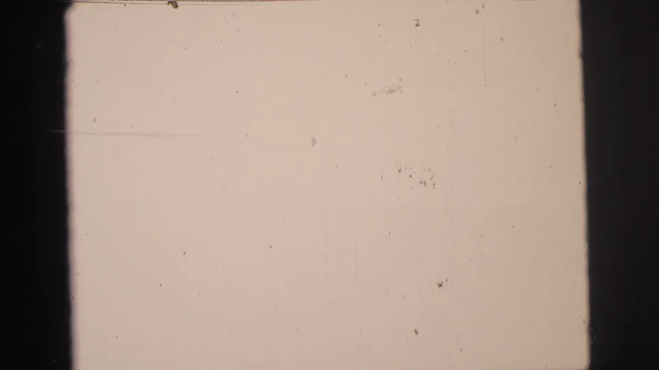The final frame is mostly overexposed, showing pale film texture, dust marks, and dark 8mm frame edges.