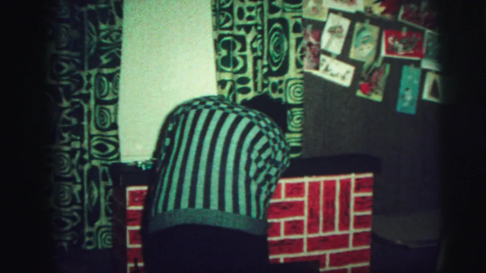 A teen in a black-and-white striped shirt bends toward the mantel in a dim 1973 Lynbrook home interior.