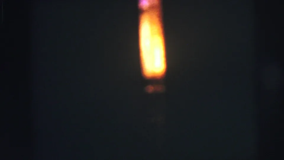 A bright yellow-orange vertical glow appears against a dark, soft-focused background in 1973 Lynbrook 8mm home-movie footage.