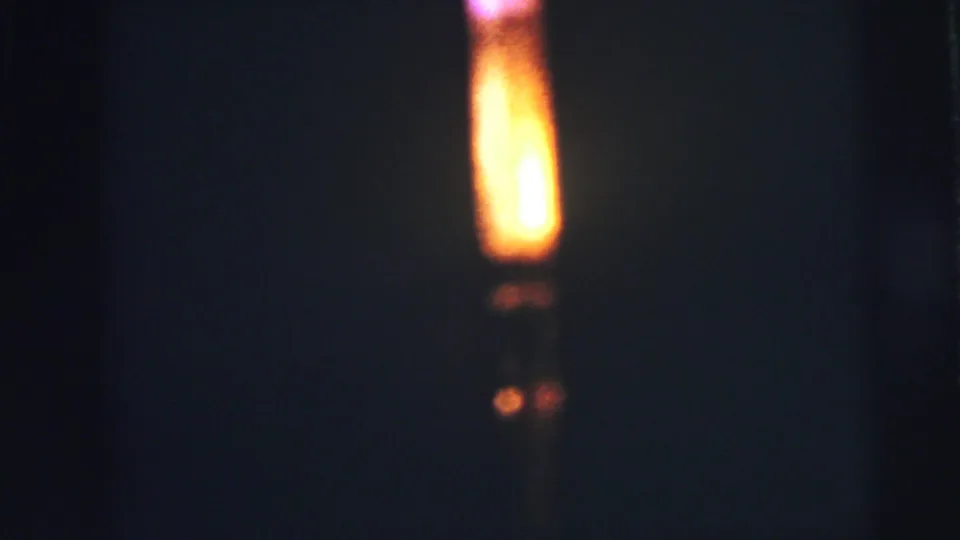 The final frame shows the same yellow-orange glow in darkness, with faint lower reflections and visible 8mm grain from Lynbrook, 1973.