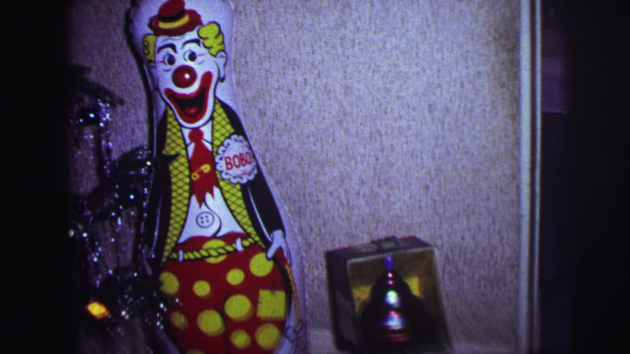 1973 Lynbrook holiday interior showing a Bobo the Clown cutout near a small boxed bell and textured wall.