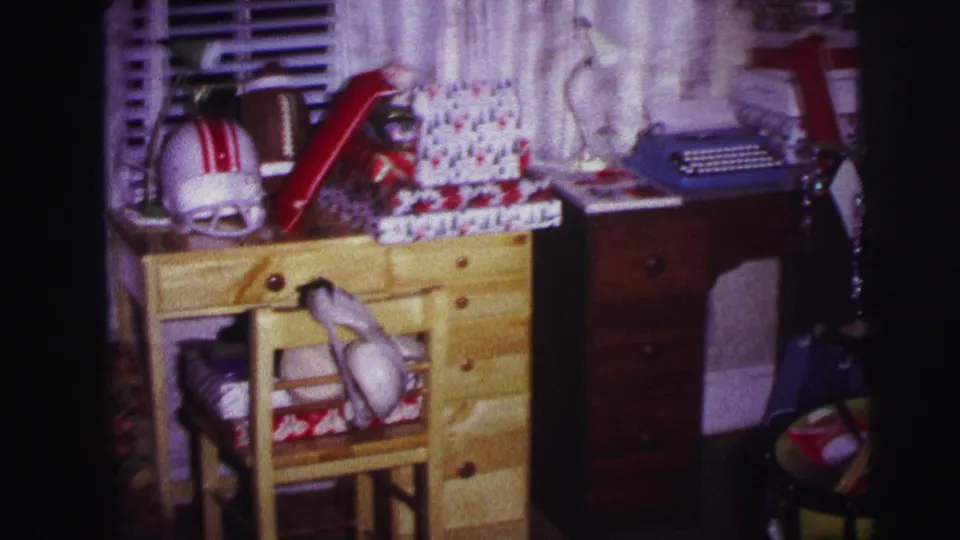 1973 Lynbrook interior showing a child's desk area with wrapped presents, football helmet, blue typewriter, toy drum, and basketball.