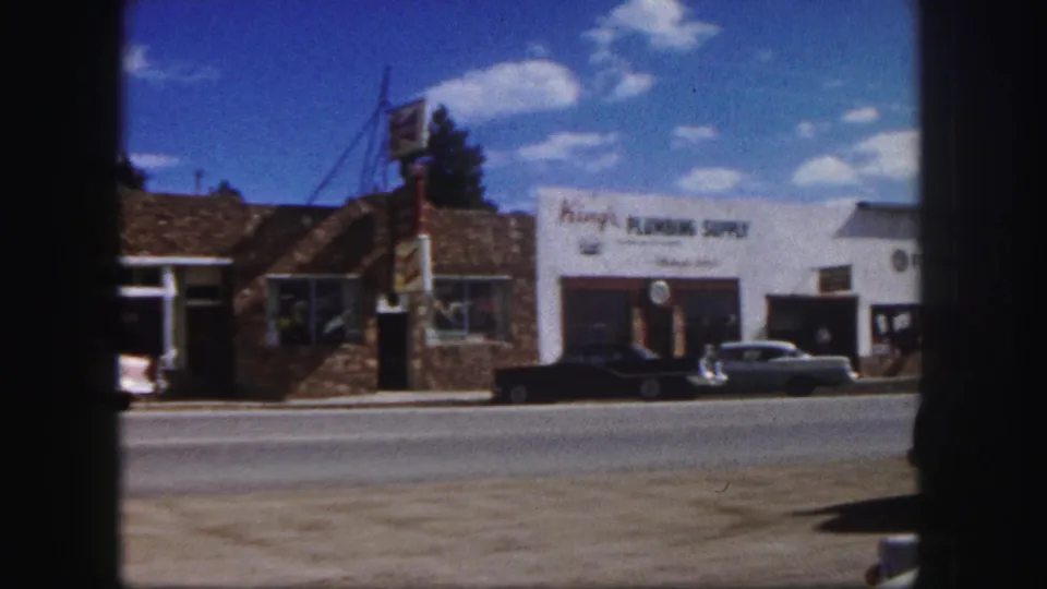 Colorado Springs commercial frontage in 1958 with King's Plumbing Supply signage and period cars along the road.