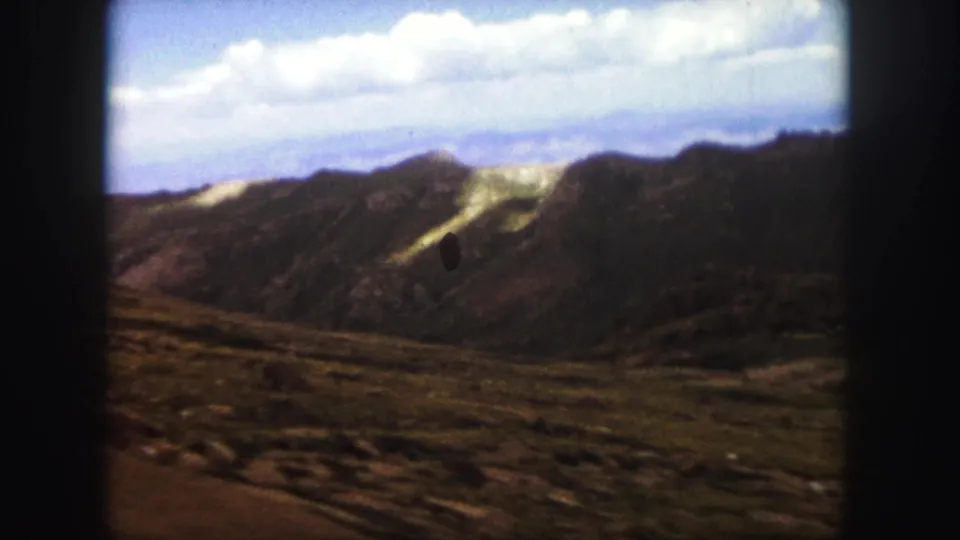 A soft 8mm frame shows arid mountain slopes and sparse scrub near Colorado Springs during a 1958 road trip.