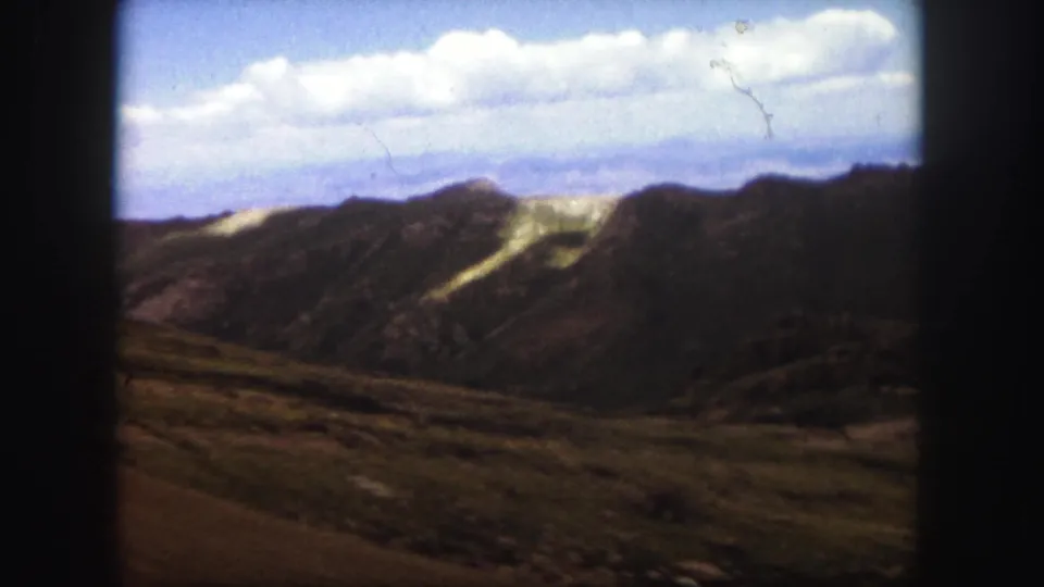 The final 1958 Colorado Springs frame holds on rugged hills, distant mountains, clouds, and visible 8mm frame edges.