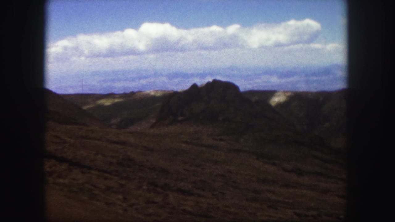 Rocky hills beneath a bright sky with dark 8mm frame borders.