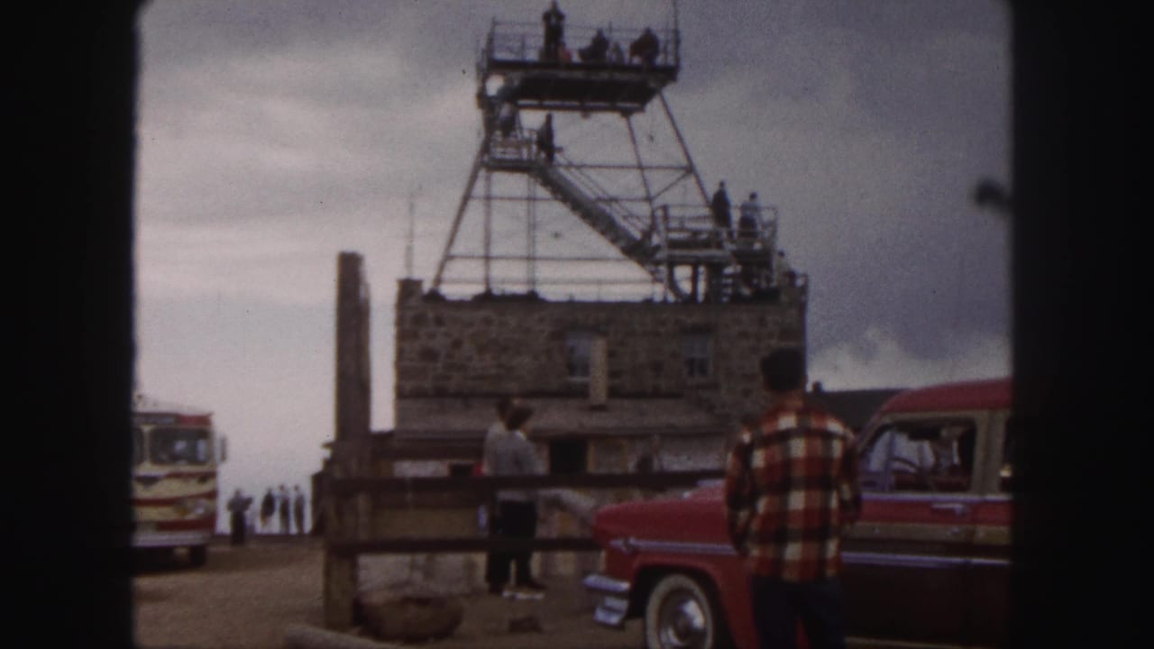 Colorado Springs 1958 travel footage frame with tourists around a stone overlook building and metal observation tower.