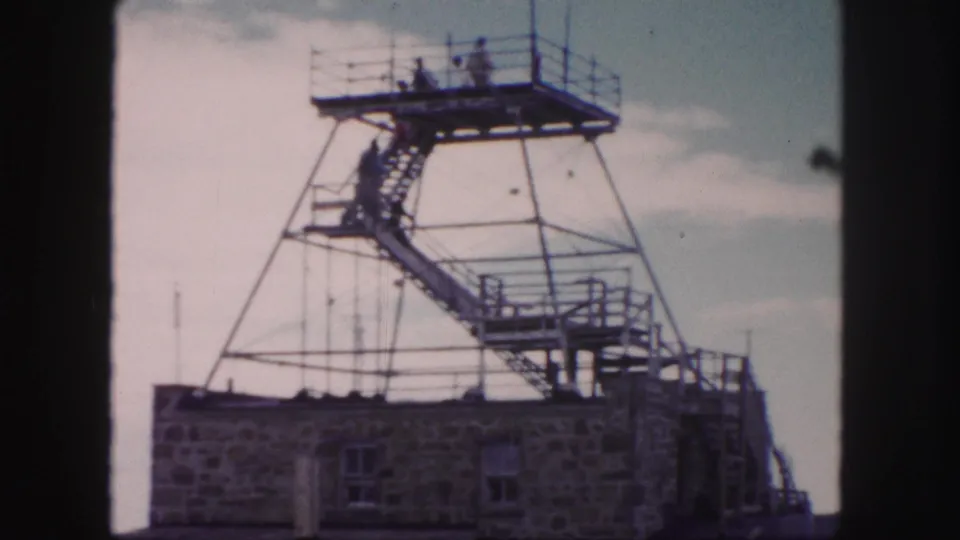 A steel observation tower with exterior stairs and visitors on the upper platform appears in the Colorado Springs travel footage.