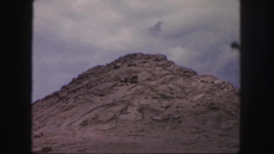 A rocky slope fills the lower frame, shot from a vehicle in Colorado Springs according to the clip metadata.