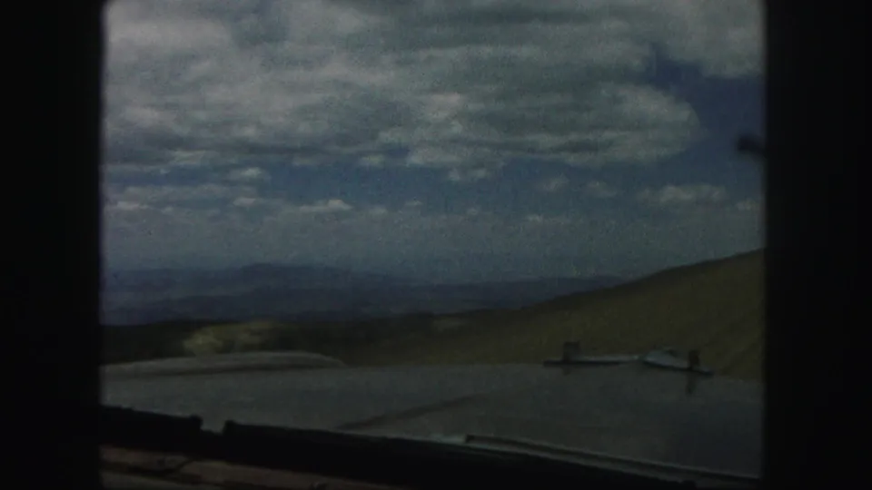 The final frame opens to distant Colorado Springs hills and heavy clouds, with part of the vehicle visible at the bottom.