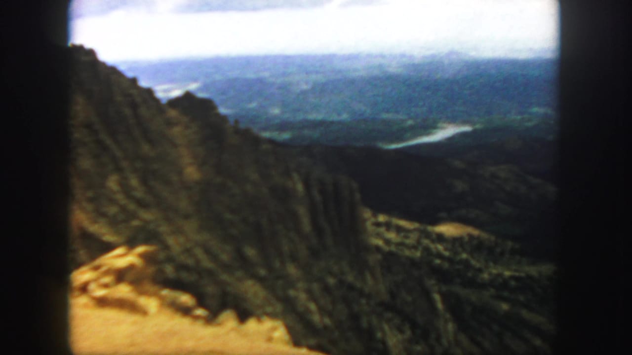 Rocky mountain ridge above a distant valley with a winding pale river.