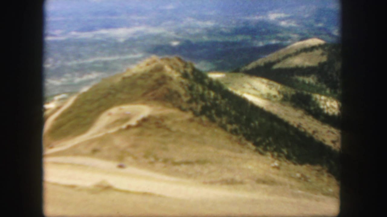Mountain peak with a winding road crossing dry slopes below.