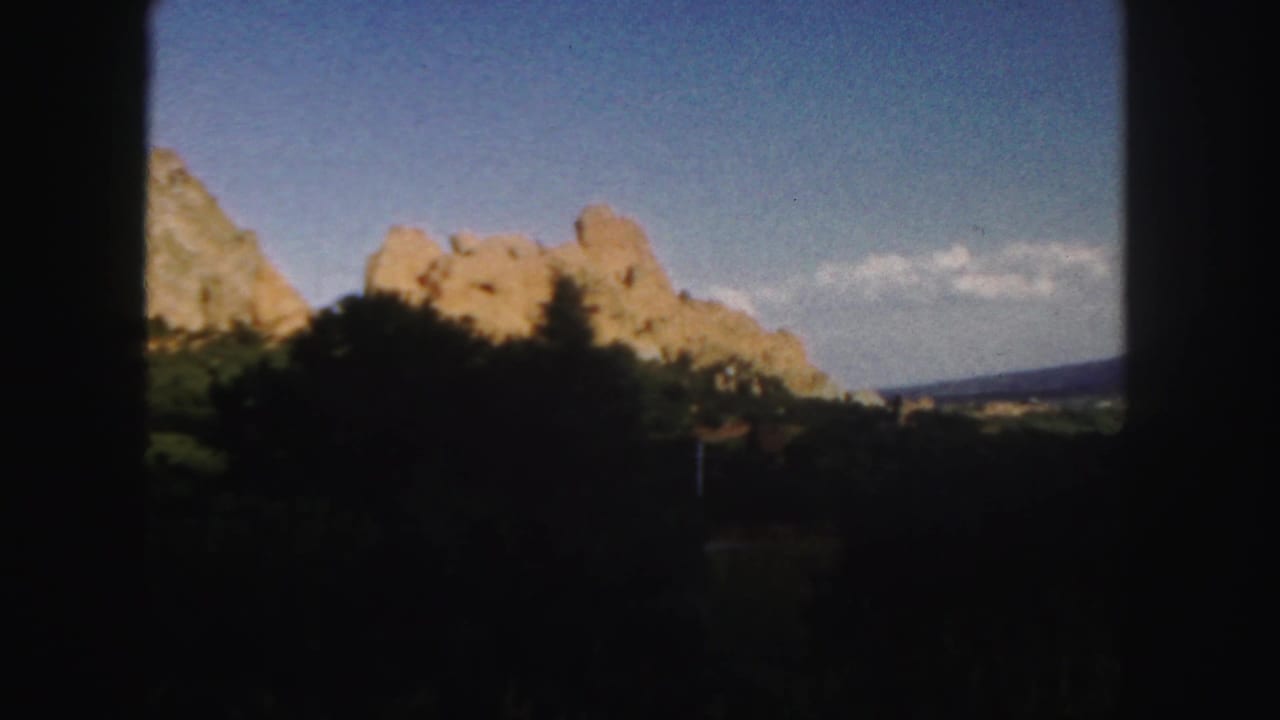 Rock spires and a distant horizon seen through dark film-frame borders.