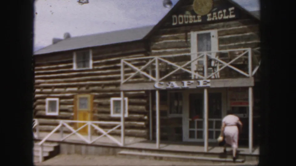 The final frame shows the woman at the porch steps of the 1958 Colorado log cabin cafe, with Double Eagle and CAFE signs above.
