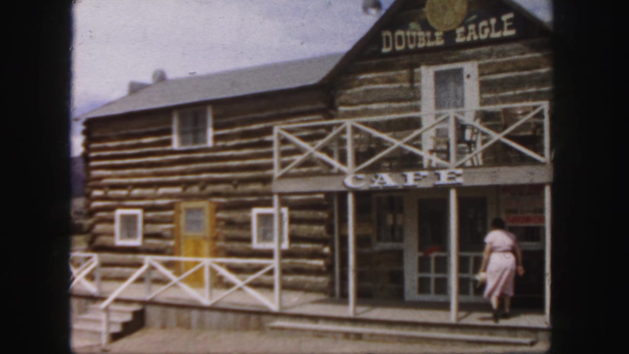 Log building labeled Double Eagle Cafe with a woman walking toward the porch.