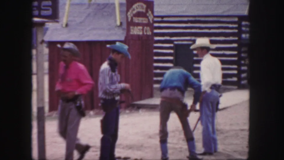 Four adult men in cowboy-style clothing meet in a Colorado frontier-style street scene on 8mm film from 1958.