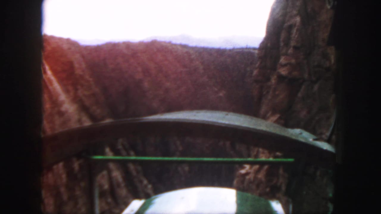 1958 Colorado 8mm view from inside a green mountain railway car, looking toward cliffs and track through a canyon.