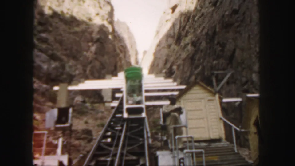 Home-movie frame from Colorado in 1958 showing the funicular track and station structures in a rocky mountain setting.