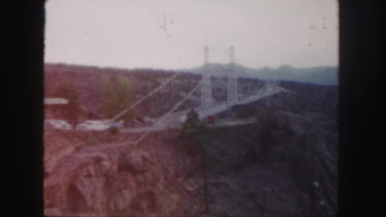 Bridge and canyon seen through reddish 8mm color shift, with cars near the span.
